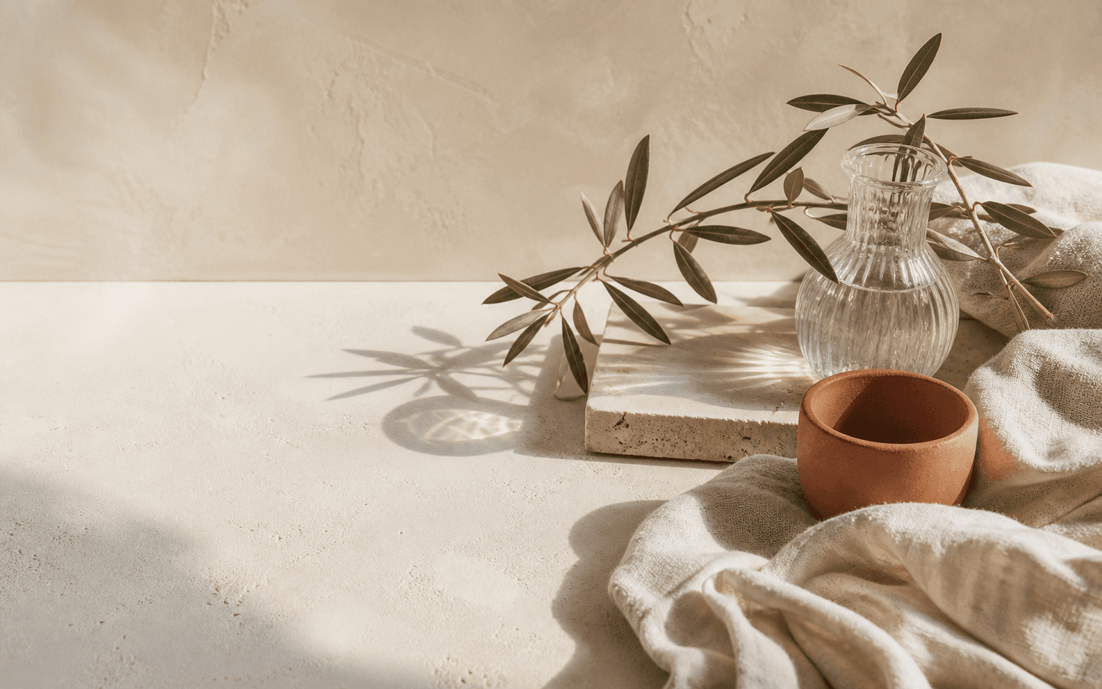 Lino natural, rama de olivo y cerámica en tonos cálidos